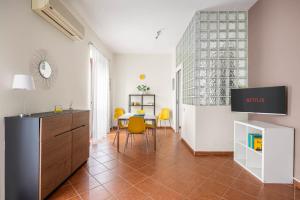 uma sala de estar com uma mesa e cadeiras amarelas em Sedie Volanti Apartment with Jacuzzi em Palermo