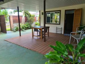 a porch with a table and a chair on it at Fare Miti-Rapa in Tohautu