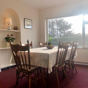 uma sala de jantar com uma mesa e cadeiras e uma janela em Faul House em Clifden
