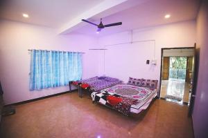 - une chambre avec un lit et un ventilateur de plafond dans l'établissement Gokul farm house, à Sasan Gir
