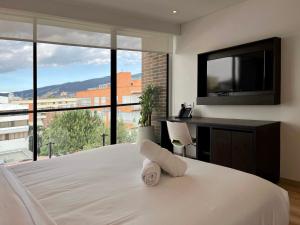 a bedroom with a large bed with a flat screen tv at Luhho Indulgence in San Patricio in Bogotá