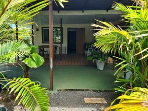 a house with a deck with a table and chairs at Fare Miti-Rapa in Tohautu