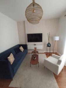 a living room with a blue couch and a table at Le Blue IVY Hyper centre 2 chambres Tout équipe in Le Creusot