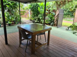 Una mesa de madera y una silla en una terraza. en Fare Miti-Rapa climatisation, baignoire et qualité pour votre confort, en Tohautu