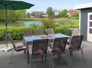 a patio with a table and chairs and an umbrella at Ferienhaus Lachmöwe in Fehmarn