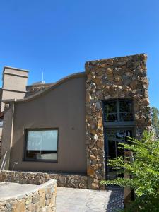 a building with a stone wall and a door at Maridaje Hosting in Ciudad Lujan de Cuyo