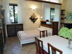 uma sala de jantar com duas mesas e cadeiras e janelas em APPARTAMENTO OASI tra LAGHI E MONTI em Borgo Ticino