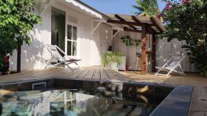 a patio with a pool and a house at Les Coulirooms - Suite avec jacuzzi et grande terrasse in Sainte-Anne