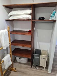 a closet with wooden shelves and a bed at Fare Miti-Rapa in Tohautu
