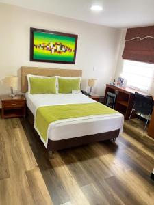 een slaapkamer met een groot bed en een bureau bij Cabecera Country Hotel in Bucaramanga