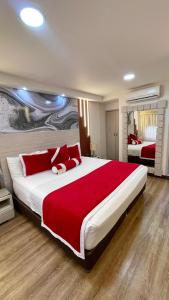 - une grande chambre avec un grand lit et des oreillers rouges dans l'établissement Cabecera Country Hotel, à Bucaramanga