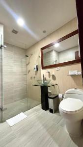 a bathroom with a toilet and a glass shower at Cabecera Country Hotel in Bucaramanga