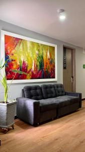 a couch in a living room with a painting on the wall at Cabecera Country Hotel in Bucaramanga +60 photos