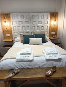 a bedroom with a large bed with two towels and shoes at Lindo pisito in León
