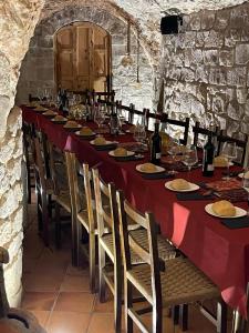 una mesa larga con platos de comida y copas de vino en La Cava de Leuvino Frias, en Presencio