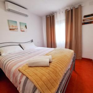 een slaapkamer met een bed met twee handdoeken erop bij Casa Blanca de La Sierra hasta 24 hasta personas con Piscina Salina y Bbq in Pelayos de la Presa