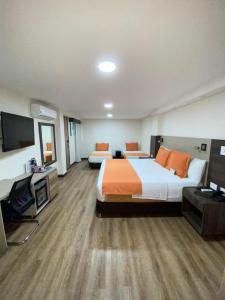 ブカラマンガにあるCabecera Country Hotelのベッド2台、薄型テレビが備わるホテルルームです。