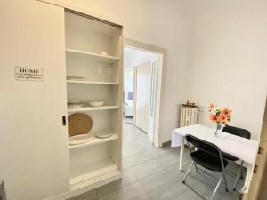 ein weißes Esszimmer mit einem Tisch und einem Regal in der Unterkunft [Porta-Venezia/Milano Centrale]Luxury Apartment in Mailand