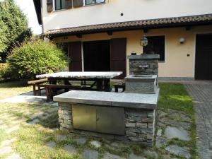 Borgo TicinoにあるAPPARTAMENTO OASI tra LAGHI E MONTIの石焼きと家の前のピクニックテーブル