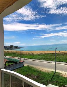 uma vista para uma estrada e para o oceano a partir de uma casa em Bela vista a beira mar em Marataizes