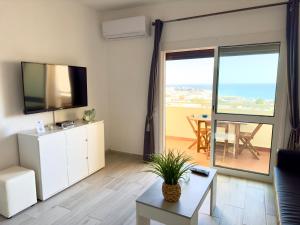 a living room with a couch and a tv and a table at Apartment Les 3 Dauphins in Albufeira in Albufeira