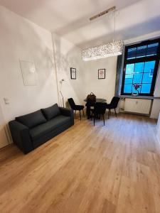 ein Wohnzimmer mit einem schwarzen Sofa und einem Tisch in der Unterkunft Wohngut-City Apt. 1 Zi. 1 DB + 1 EZ 34 qm mit Parkplatz in Hagen