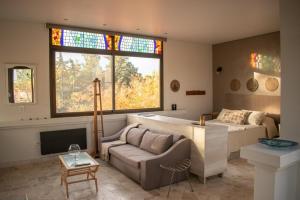 sala de estar con sofá, cama y ventana en Maridaje Hosting en Luján de Cuyo