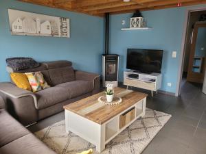 a living room with a couch and a tv at vakantiehuisjes-Vissershuisjes Wenduine in Wenduine