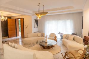 a living room with white furniture and a glass table at Villa Victoria in Tunis