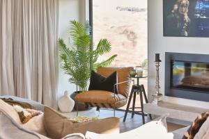 a living room with a couch and a plant at Ocean + Country - Wainui Beach in Gisborne