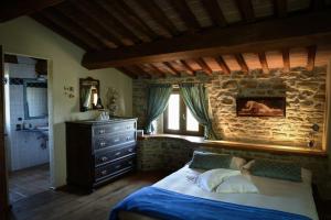 una camera da letto con un letto e un muro di pietra di Stunning villa with pool, Jacuzzi and wonderful view ad Apecchio