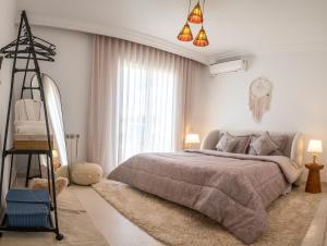 Villa Victoria في تونس: غرفة نوم بسرير ونافذة كبيرة