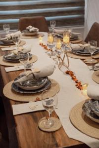 a long wooden table with plates and wine glasses at Villa Victoria in Tunis