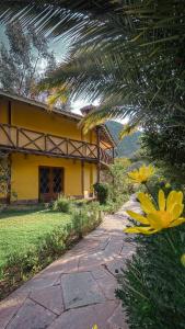 une passerelle devant un bâtiment jaune dans l'établissement Andean Wings Valley, à Urubamba