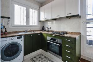 a kitchen with green cabinets and a washing machine at Penthouse Inlakesh in Valencia