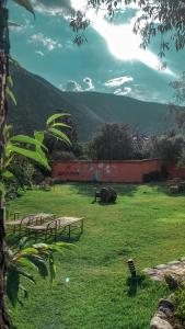 a park with benches in a field with a mountain at Andean Wings Valley in Urubamba