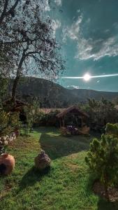 a yard with a gazebo with the sun in the sky at Andean Wings Valley in Urubamba