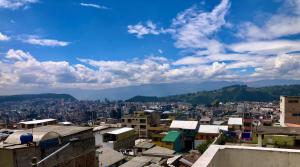 a view of a city with buildings and mountains at Llamingo Hostel in Quito