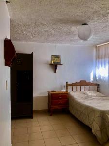 1 dormitorio con cama, tocador y mesa en Llamingo Hostel, en Quito