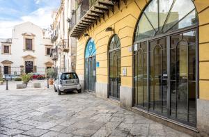 a small car parked in front of a building at Sedie Volanti Apartment with Jacuzzi in Palermo