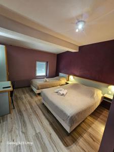 2 camas en un dormitorio con paredes moradas en Hôtel Restaurant Les Alizes Loriol Le Pouzin, en Le Pouzin