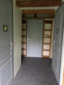 an empty closet with a door and shelves at gite de la Chevrie in La Baconnière