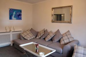 a living room with a couch and a mirror at Amazing 2-Bed Home w/ Private Garden Free Parking in Cardonald