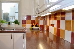 a kitchen with a bowl of fruit on the counter at Amazing 2-Bed Home w/ Private Garden Free Parking in Cardonald +16 photos