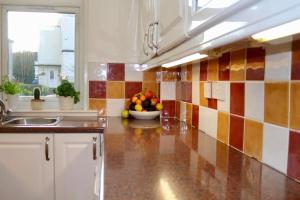 a kitchen with a bowl of fruit on the counter at Amazing 2-Bed Home w/ Private Garden Free Parking in Cardonald