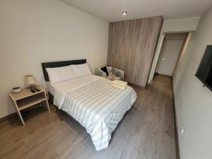 Dormitorio pequeño con cama y mesa auxiliar en Espacio Luxury Apartments “Edificio Boutique B51”, en Lima