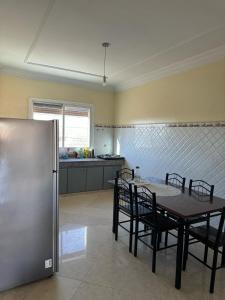 a kitchen with a table and chairs and a refrigerator at Apartement Boulevard Mohammed Derfoufi Oujda in Oujda