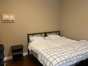 a bedroom with a bed with a white comforter at Quiet apt only 15 mins away from Midtown Manhattan in Jersey City