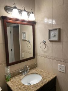 a bathroom with a sink and a mirror at Quiet apt only 15 mins away from Midtown Manhattan in Jersey City