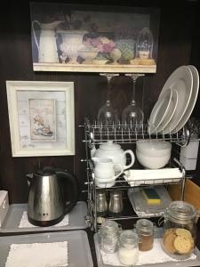 a kitchen with a shelf with plates and dishes at The Old Merchants House - The Vettriano Room in Southampton